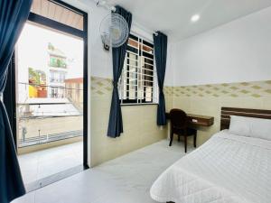 胡志明市DREAM HOUSE的一间卧室配有一张床、一张书桌和一个窗户。