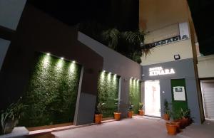 艾哈迈达巴德Hotel Kinara的墙上有植物和灯的建筑