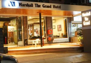艾哈迈达巴德Marshall The Grand Hotel的一家大酒店前面的商店,里面摆放着椅子