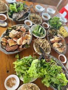 Trai ÐỏĐảo Chè Thanh Chương - Điếu Cày Travel的一张木桌,上面放着食物盘