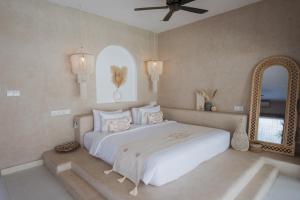 吉利特拉旺安Gili Boho Villas - Aesthetic Private Pool Villas的卧室配有一张白色大床和镜子