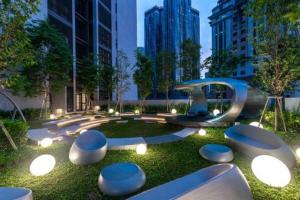 吉隆坡Scarletz Suites KLCC Deluxe Studio Room Single Double Bed的草丛中有一排凳子的公园