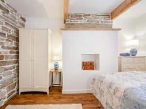 Winter Cottage的一间卧室设有一张床和砖墙