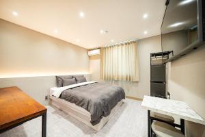 群山市Hey Gunsan Hotel的一间卧室配有一张床和一张书桌