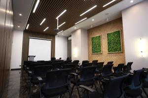 杜尚别IsraHotel Dushanbe的一间会议室,配有黑色椅子和绿色的墙壁