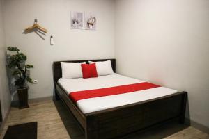 泗水K1 UPN的一间小卧室,配有一张带红色毯子的床