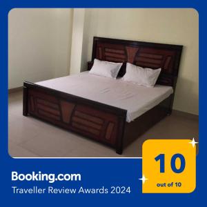 贾巴尔普尔SPOT ON 81358 Sun Shine Hotel的一间卧室配有一张带木制床头板的床