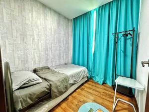 古晋YM Homestay Vivacity megamall Jazz Suite 3 bedroom 8 pax的一间小卧室,配有床和蓝色窗帘