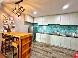 古晋YM Homestay Vivacity megamall Jazz Suite 3 bedroom 8 pax的厨房配有木桌和冰箱。
