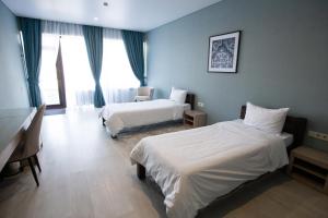 QaskelengArman Dala Resort的酒店客房配有两张床和一张书桌