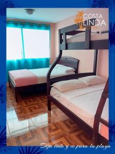 萨利纳斯Hostal Costa Linda Salinas的一间卧室设有两张双层床和一扇窗户。