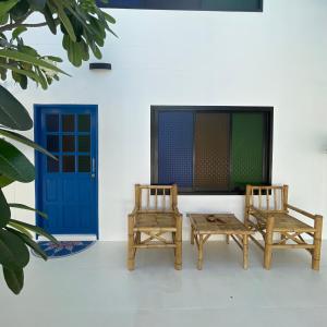高兰Acqualanta House的两把椅子和一张桌子以及一扇蓝色的门