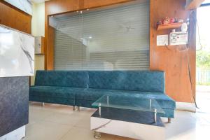 印多尔FabHotel Grand Giriraj的配有大窗户的客房内的蓝色沙发