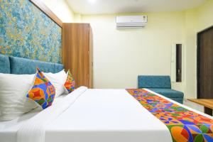 印多尔FabHotel Grand Giriraj的酒店客房,配有一张床和两张蓝色椅子