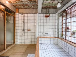 清迈Woo Ma Ca Moo的带淋浴的浴室和白色瓷砖墙壁。