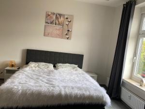 库克斯港Ferienwohnung PIER 1 in Cuxhaven的卧室配有一张带白色棉被的床和窗户。