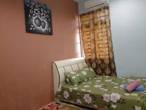 PendangHomestay Ainul的一间卧室配有一张带绿色棉被的床和窗户。