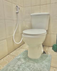 莫希Goodtimewithfar House的浴室内设有一个白色的卫生间,配有软管