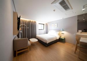 釜山Nampo Ocean2Heaven Hotel& Spa的配有一张床和一把椅子的酒店客房