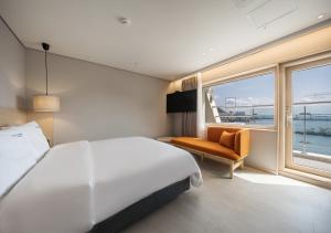 釜山Nampo Ocean2Heaven Hotel& Spa的卧室设有一张白色大床和一扇窗户。