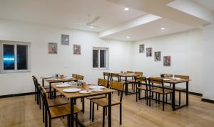 海得拉巴Treebo Trend SY Inn - Gachibowli DLF的用餐室配有木桌和椅子
