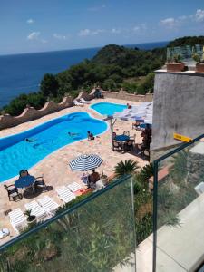 乌斯蒂卡Hotel Diana的享有带椅子的游泳池和大海的景色