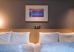 釜山Nampo Ocean2Heaven Hotel& Spa的一间卧室配有两张带白色枕头的床
