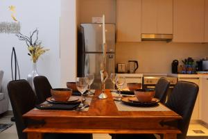 阿布扎比Twilight 1BR apartment Yas Island的餐桌、椅子和桌子及酒杯
