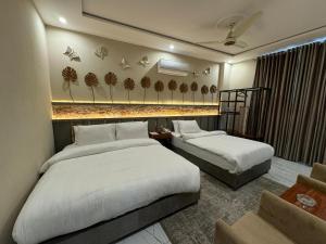 拉合尔Shelton Boulevard Hotel Lahore的一间酒店客房,房间内设有两张床