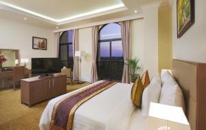 胡志明市莫尔珀尔水晶宫酒店的一间卧室配有一张大床和电视