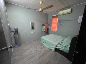 Kampong Batu LapanMP Homestay Lost world of tambun的小房间设有一张床和一个风扇