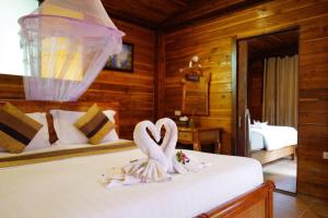 丽贝岛Anda Lipe Resort的卧室里床边的两只天鹅