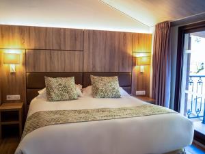 阿林萨尔Hotel Princesa Parc的卧室配有一张白色大床和木墙