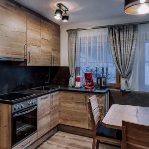 NavisBergler Hoamat 5 - 8 Personen的厨房配有木制橱柜和一张桌子。