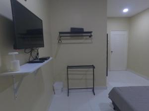 珍南海滩NURUL ROOMSTAY LANGKAWI的客厅配有电视和带电脑的书桌
