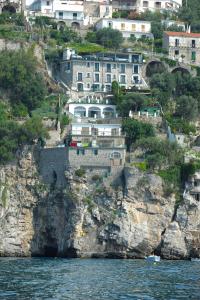 普莱伊亚诺玛丽亚皮亚别墅酒店的悬崖边的水边的建筑物