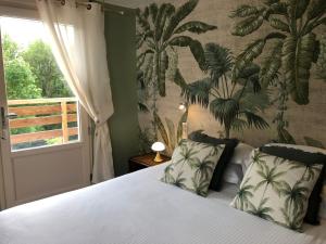 阿宰勒里多Logis Hôtels Troglododo的一间卧室配有一张带热带壁纸的床