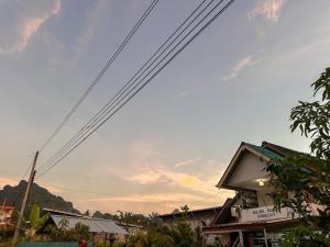 甲米镇Ao Luek Homie Homestay的建筑物上方有电源线的云天