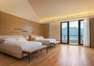 印渚杭州桐庐康莱德酒店的一间卧室设有两张床和大窗户