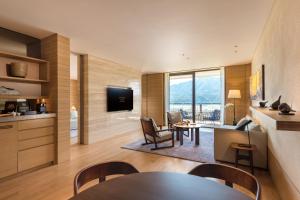 印渚杭州桐庐康莱德酒店的客厅配有桌椅和电视。