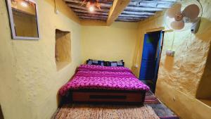 AijuWildernest retreat by ranjan的一间卧室配有一张带紫色毯子的床