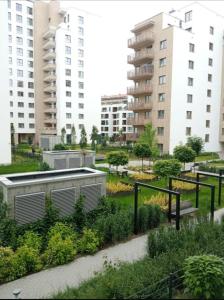 华沙Apartamenty Bokserska的一座高楼城市的花园
