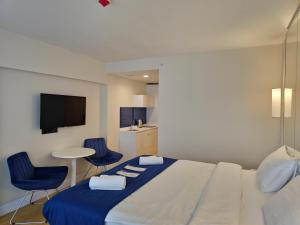 巴统Twin Towers Orbi City Batumi的一间卧室配有一张床、两把椅子和一张桌子