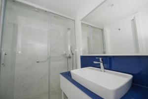 巴统Twin Towers Orbi City Batumi的浴室配有白色水槽和玻璃淋浴间。