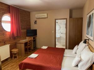 Dabas鹦鹉螺餐厅住宿加早餐旅馆的一间卧室配有一张床、一台电视和一间浴室。