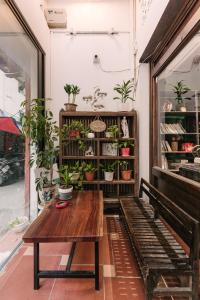 河内Harmony Homestay - Hanoi Homestay in Old Quarter的一间设有木桌和盆栽植物的客房