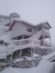 纳尔卡恩达THE WONDERLAND COTTAGES & Cafe的雪中房屋 - 带阳台