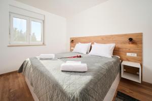 萨武德里亚Apartma Morje的一间卧室配有一张带两个白色枕头的大床