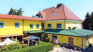 瓦格纳Hotel Restaurant Neuhold的红色屋顶的大型黄色建筑