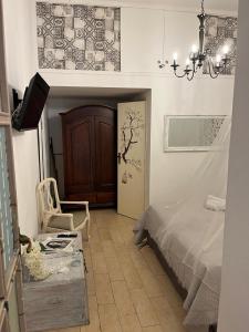 巴勒莫La Siciliana-di fronte la Cattedrale的一间卧室配有一张床、一把椅子和一个吊灯。